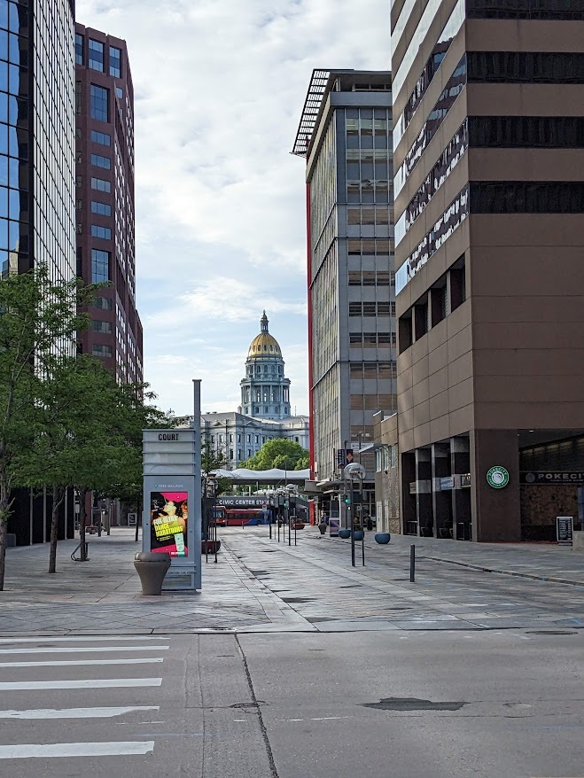 View down a Denver city street with the state capitol building visible in the distance